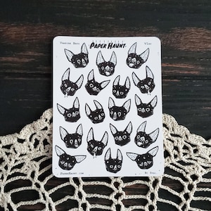 May include: A sheet of stickers featuring 16 black and white illustrations of bats. The stickers are arranged in a grid pattern and are labeled "Vampire Bats" and "Paper Haunt".