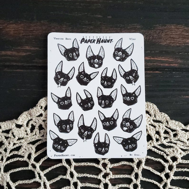 May include: A sheet of stickers featuring 16 black and white illustrations of bats. The stickers are arranged in a grid pattern and are labeled "Vampire Bats" and "Paper Haunt".
