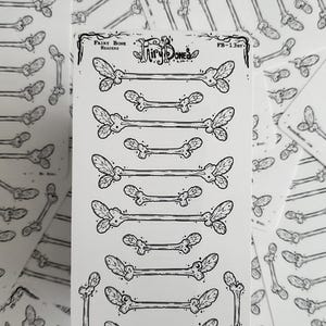 May include: A sheet of black and white stickers featuring stylized bone designs with leaf-like accents. The text "Fairy Bone Headers" and "Fairy Bones" is visible. The stickers are arranged in rows, with additional stickers scattered around.