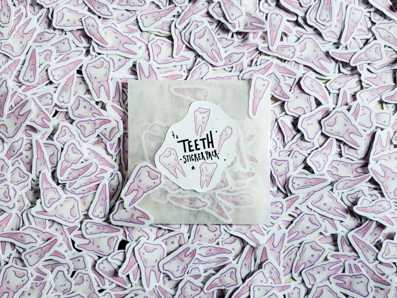 May include: A white envelope containing a sticker pack of pink and purple tooth illustrations. The sticker pack is labelled "Teeth - Sticker Pack".