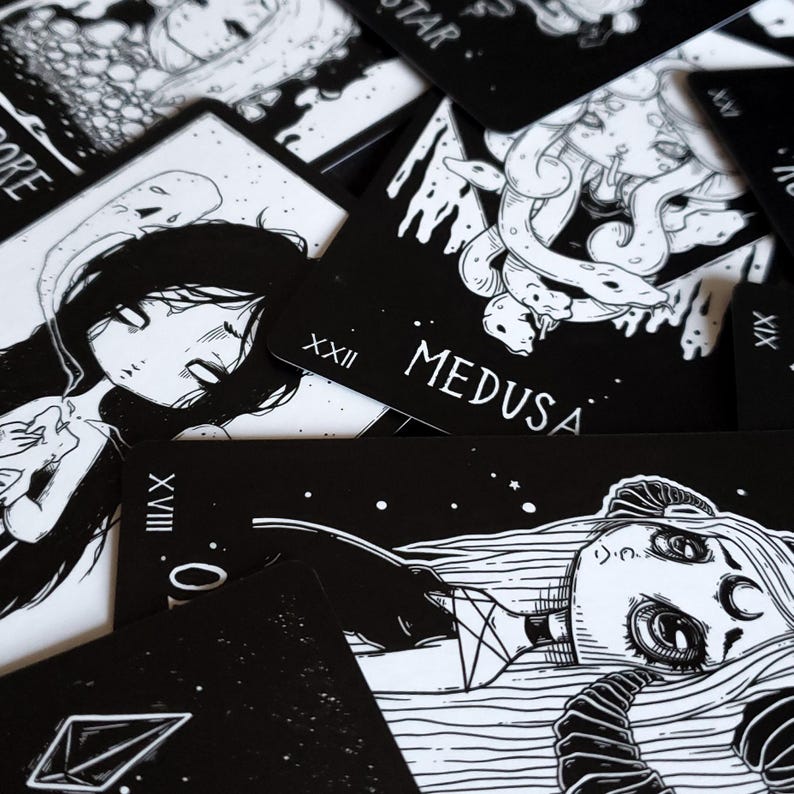 May include: Black and white tarot cards with illustrations of women and mythical creatures. The cards feature Roman numeral numbers and titles such as "Medusa" and "The Star".