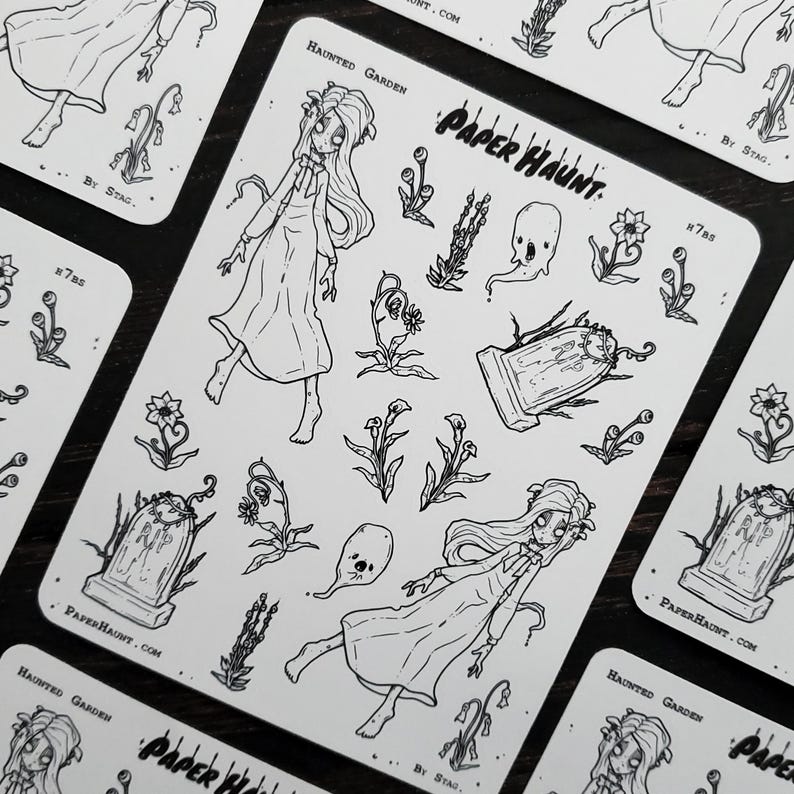 May include: A sheet of black and white stickers featuring a haunted garden theme. The stickers include a ghost, a tombstone, flowers, and two girls in dresses. The text "PAPER HAUNT" is printed on the sheet.