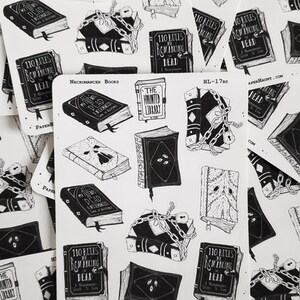 May include: A set of 10 black and white stickers featuring illustrations of books with titles like "All My Friends Are Dead", "The Haunted Library", and "110 Rules for Romancing the Dead". The stickers are part of a collection called "Necromancer Books" and are designed by Paper Haunt.