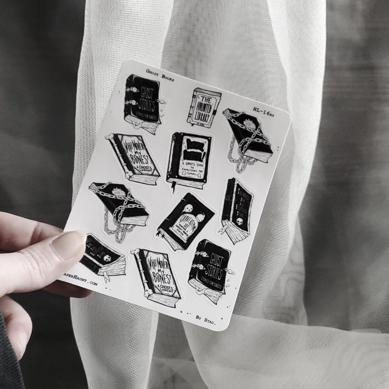 May include: A sheet of stickers featuring black and white illustrations of books with spooky titles like "Ghost Stories", "The Haunted Library", and "Where My Bones Are Buried". The stickers are on a white background and have a distressed, vintage look.