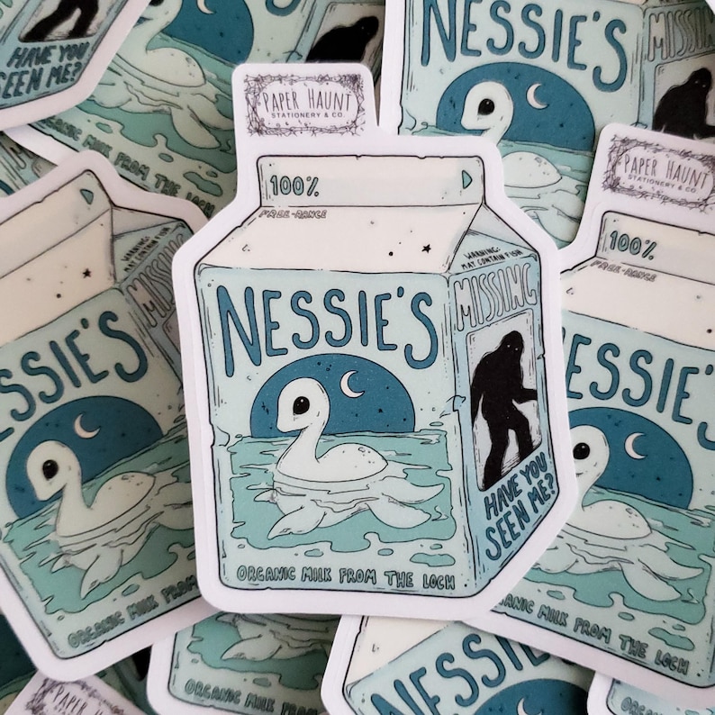 K&ouml;nnte beinhalten: Ein Aufkleber mit einem Cartoon-Milchkarton mit den Worten "Nessie's" und "Organic Milk from the Loch". Der Karton ist in Blau- und Wei&szlig;t&ouml;nen gehalten und zeigt eine Cartoon-Nessie mit einem Halbmond dar&uuml;ber. Der Karton hat auch ein Warnschild mit der Aufschrift "Missing" und einer Silhouette einer Person daneben. Der Text "Have you seen me?" steht unter der Silhouette.