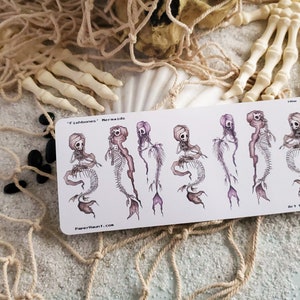 Fishbones mermaid skeleton sticker sheet in the sand on the beach
