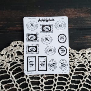 May include: A sheet of stickers featuring black and white illustrations of eyes in various frames. The stickers are titled "Lover's Eye" and "Paper Haunt." The text "By Stag." appears at the bottom of the sheet.