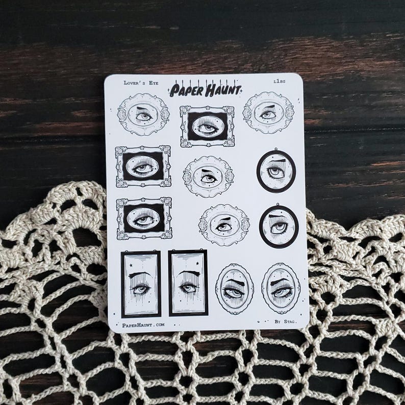 May include: A sheet of stickers featuring black and white illustrations of eyes in various frames. The stickers are titled "Lover's Eye" and "Paper Haunt." The text "By Stag." appears at the bottom of the sheet.
