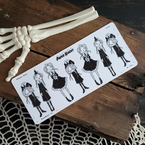 May include: A sheet of black and white stickers featuring illustrations of pumpkin girls in various poses. The stickers are labeled "Pumpkin Girls" and "Paper Haunt."