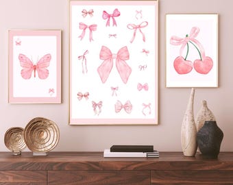 May include: Three framed prints with pink watercolor illustrations. The first print features a pink butterfly. The second print features a collection of pink bows. The third print features two pink cherries with a pink bow.