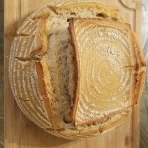 May include: A freshly baked sourdough loaf with a crisp crust and a soft, airy interior. The bread is sliced open, revealing the intricate patterns of the dough.