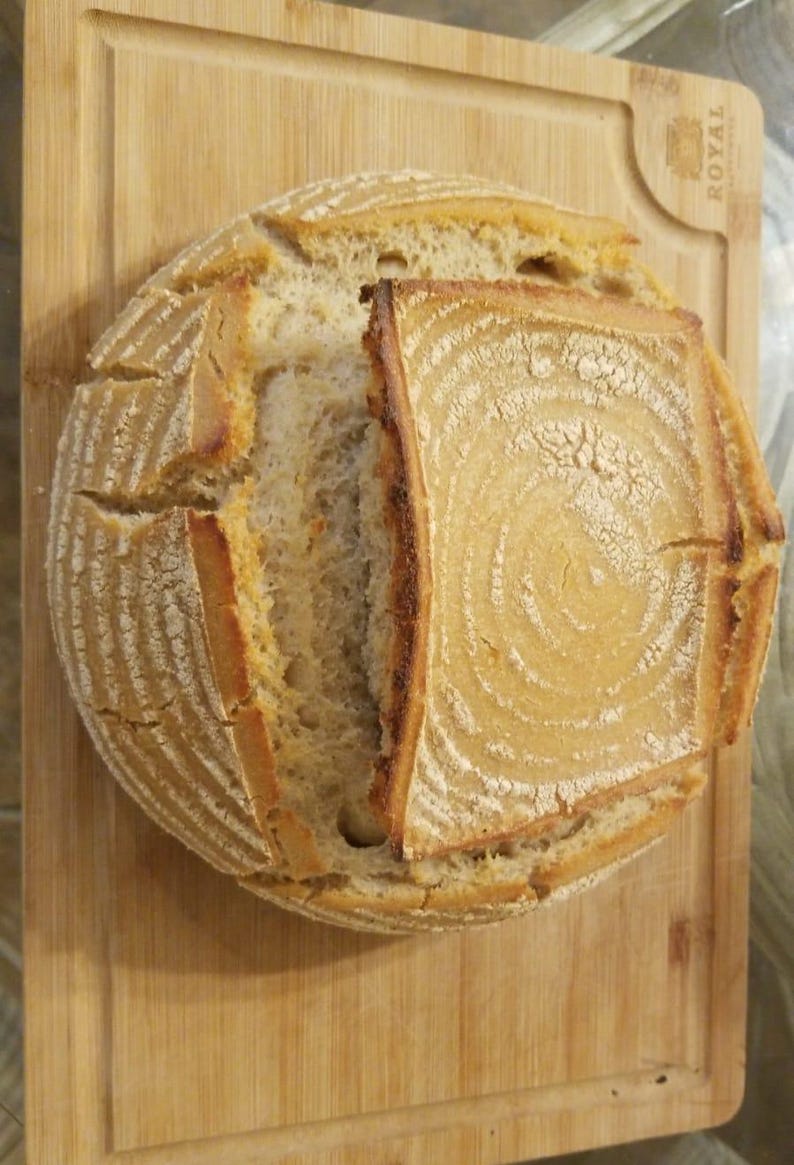 May include: A freshly baked sourdough loaf with a crisp crust and a soft, airy interior. The bread is sliced open, revealing the intricate patterns of the dough.