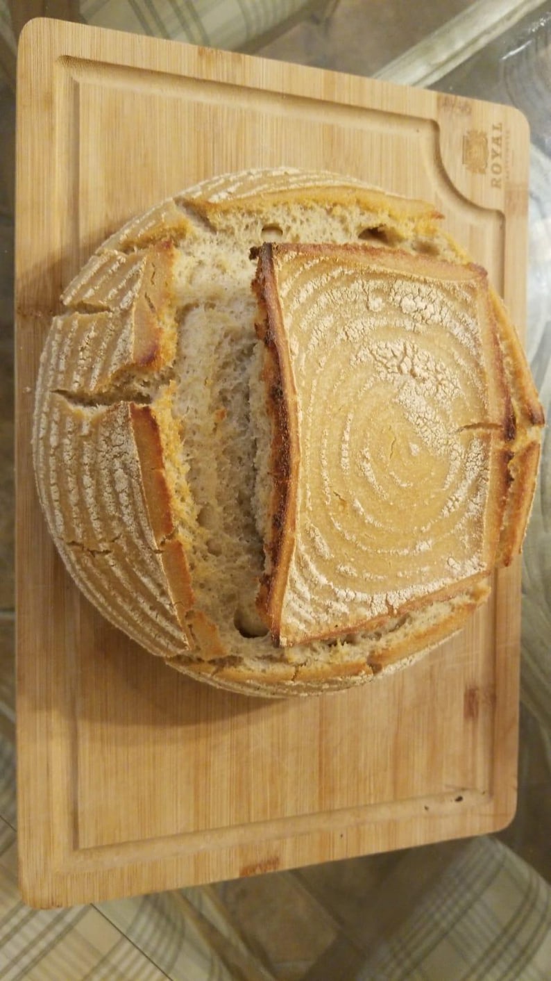 May include: A freshly baked loaf of sourdough bread with a crispy crust and a soft, airy interior. The bread is sliced open, revealing the intricate patterns of the dough.