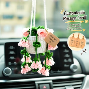 May include: A handmade crochet hanging flower basket with pink flowers and green leaves. The white basket has a tag that says "Drive safe Love you". The image also includes text that says "Customizable Message Card!"
