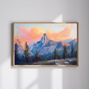 May include: A framed landscape painting depicts a mountain range under a sunset sky. The artwork features a prominent, light-colored mountain peak, with other peaks in the background. The sky is a blend of orange and pink hues, and the foreground shows trees.