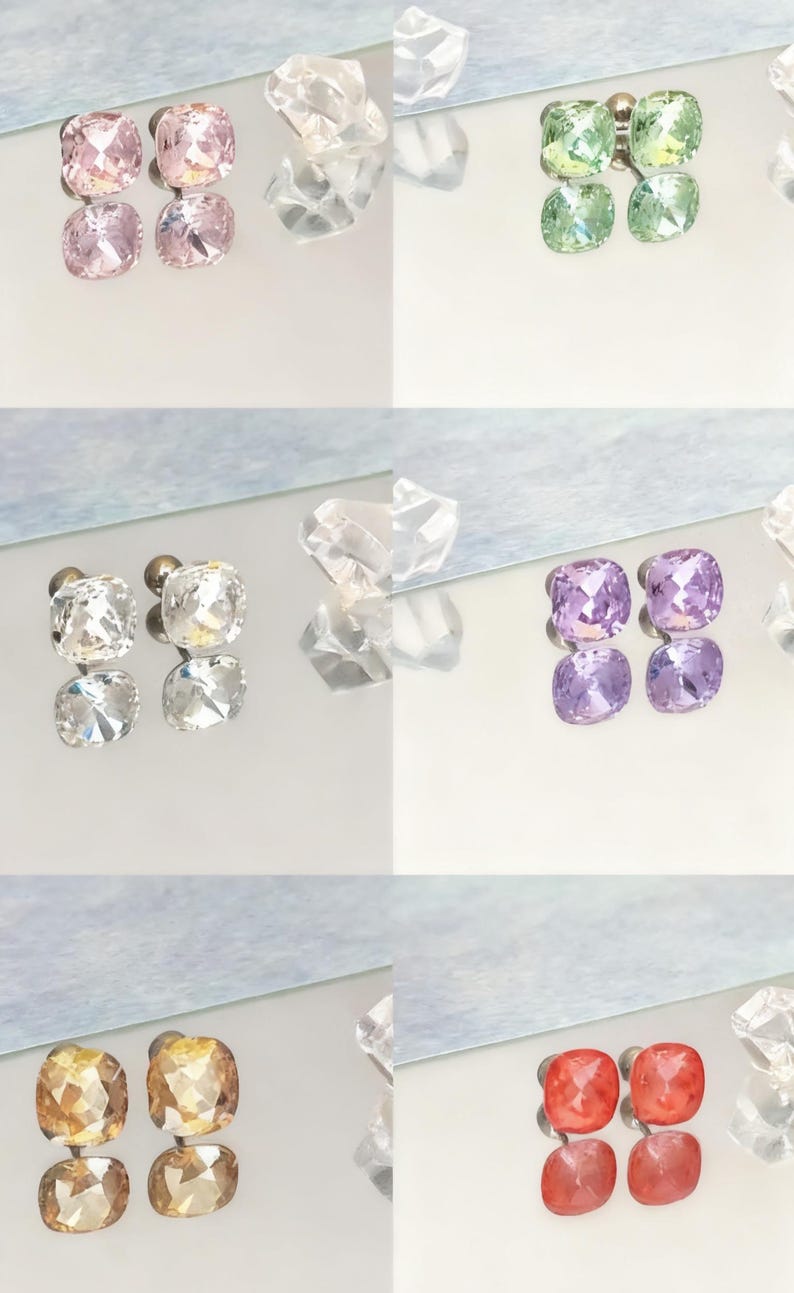 May include: A collection of square-cut stud earrings in various colors, including pink, green, clear, purple, gold, and red. The earrings are displayed on a reflective surface, showcasing their facets and sparkle. The image highlights the different color options available.