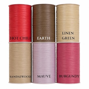May include: A selection of spools of decorative raffia ribbon in various colors. The colors include Hot Chili red, Earth brown, Linen Green, Sandalwood, Mauve, and Burgundy. Each spool is labeled with its color name.