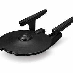 May include: A black model starship, featuring a circular main hull and two rectangular warp nacelles. The model has detailed features and is set against a white backdrop.