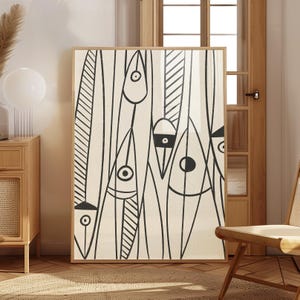 Op de afbeelding: Abstracte kunstafdruk in een houten lijst. Het kunstwerk toont zwarte lijntekeningen van gestileerde vormen en patronen op een crèmekleurige achtergrond. De vormen omvatten oogachtige vormen en verticale lijnen.