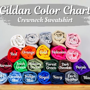 May include: A color chart for Gildan crewneck sweatshirts. The chart displays a variety of rolled-up sweatshirts in colors such as white, red, orange, and purple. The text "Gildan Color Chart Crewneck Sweatshirt" is at the top.