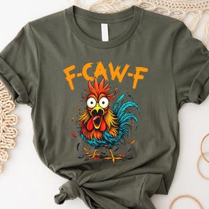 a t-shirt with a colorful graphic of a rooster and the text "F-CAWF-F" printed on it.