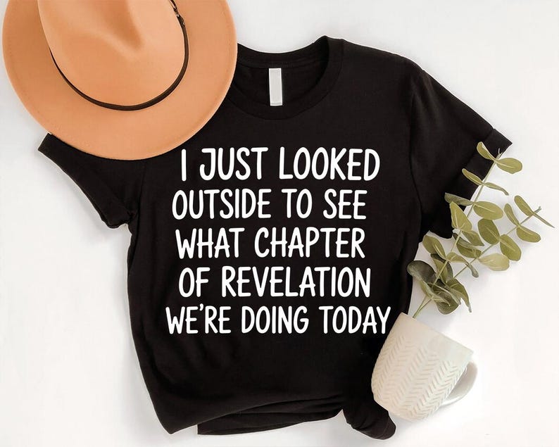 a black t-shirt with white text, a brown hat, a white mug, and a plant, all arranged on a white background.