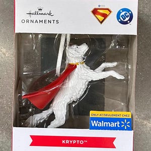 Pode incluir: Enfeite de árvore de Natal Hallmark com Krypto, o cão do Superman, com capa vermelha e coleira dourada. O cão branco está em uma pose dinâmica. A embalagem inclui os logotipos do Superman e da DC Comics.