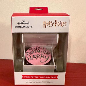 以下が含まれることがあります： 「Happee Birth Dae Harry」の文字が緑色のアイシングで書かれたピンク色のケーキが特徴の、Hallmarkのクリスマスツリーオーナメント。オーナメントは、ハリー・ポッターのロゴと「Harry Potter Birthday Cake」の文字が入った箱に入っています。