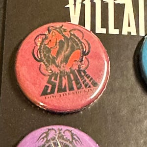 K&ouml;nnte beinhalten: Ein runder, roter Button mit einer Grafik von Scar aus Disneys Der K&ouml;nig der L&ouml;wen. Der Button hat das Wort "SCAR" in schwarzer Schrift, mit dem Satz "LONG LIVE THE KING" darunter. Das Disney Villains Logo ist sichtbar.