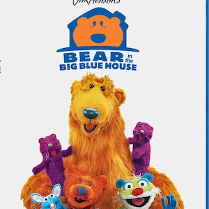May include: A Blu-ray disc case for Jim Henson's Bear in the Big Blue House: The Complete Series. The cover features a large orange bear surrounded by smaller purple, red, and green puppet characters against a plain white background.