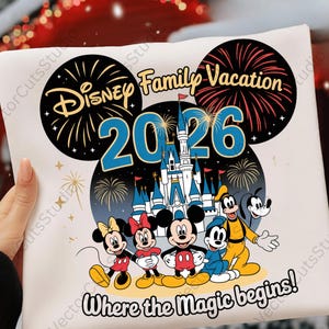 May include: A white t-shirt featuring a colorful graphic design for a Disney family vacation in 2026. The design includes Mickey Mouse, Minnie Mouse, Donald Duck, Goofy, and Pluto, with fireworks and a castle.