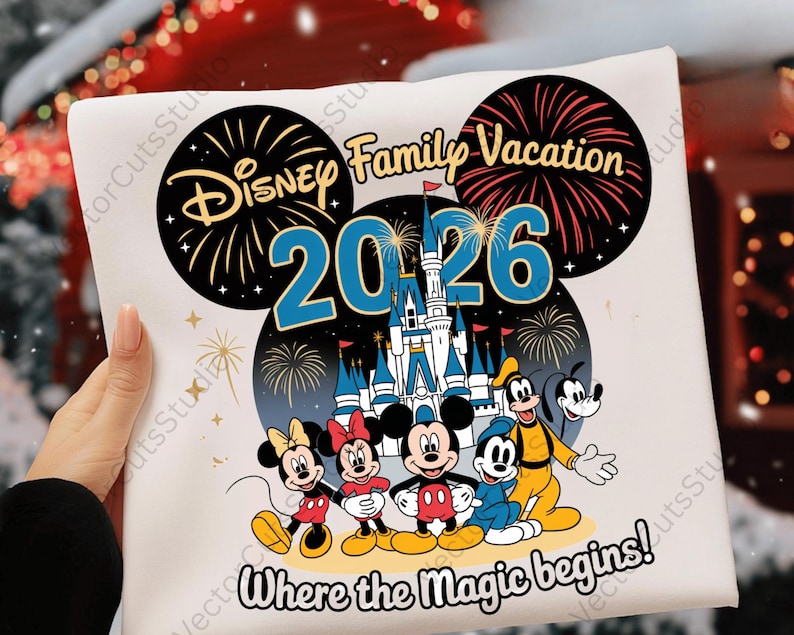 May include: A white t-shirt featuring a colorful graphic design for a Disney family vacation in 2026. The design includes Mickey Mouse, Minnie Mouse, Donald Duck, Goofy, and Pluto, with fireworks and a castle.