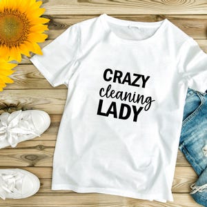 May include: White t-shirt with the text "CRAZY cleaning LADY" in black lettering.