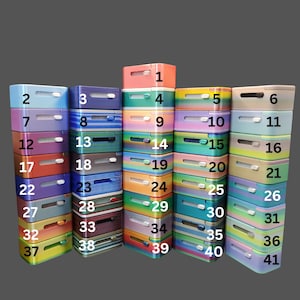 Puede incluir: Una pila de 41 cajas rectangulares de colores con los números del 1 al 41 impresos en la parte delantera. Las cajas son de metal y tienen una variedad de acabados iridiscentes.