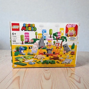 May include: A LEGO Super Mario Creativity Toolbox set, featuring colourful building blocks and characters. The box displays the Super Mario logo, age 6+, and the text "Create Your Own Levels". Contains 588 pieces.