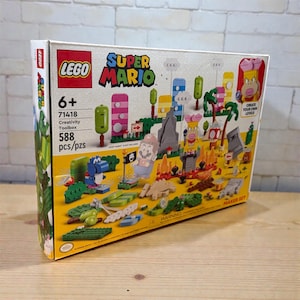 May include: A LEGO Super Mario Creativity Toolbox set, with colourful building blocks and characters. The box displays the LEGO and Super Mario logos, with the text "6+", "71418", "Creativity Toolbox", and "588 pcs/pzs". The set includes various figures and scenery.
