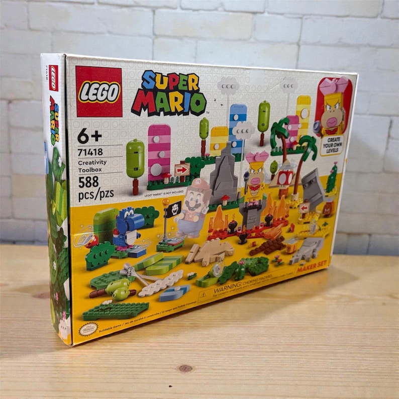 May include: A LEGO Super Mario Creativity Toolbox set, with colourful building blocks and characters. The box displays the LEGO and Super Mario logos, with the text "6+", "71418", "Creativity Toolbox", and "588 pcs/pzs". The set includes various figures and scenery.