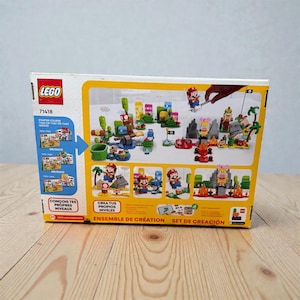 May include: A LEGO Super Mario Starter Course box set. The box is yellow and white, with images of the set's contents, including Mario figures, obstacles, and environments. Text on the box includes "LEGO", "71418", and "Starter Course".