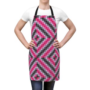 May include: A pink and black checkered apron with adjustable straps. The apron is made of a durable fabric and is ideal for protecting your clothes while cooking or baking.