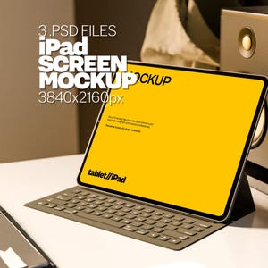 May include: A mockup of an iPad screen with a yellow background. The iPad is on a white surface with a keyboard attached. The text on the screen reads "tablet//iPad".