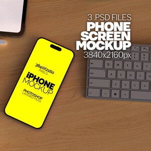 Może przedstawiać: Żółta makiety iPhone'a z tekstem "IPHONE MOCKUP" i "3840x2160 PIXELS" na ekranie. Telefon leży na drewnianej powierzchni obok szarej klawiatury.