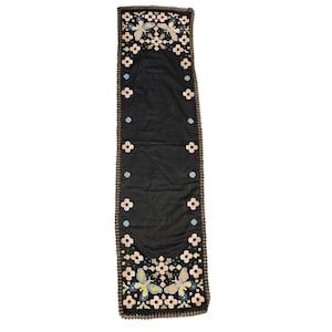 May include: A rectangular black table runner featuring embroidered butterfly motifs at both ends. The design includes small light pink and blue flower patterns along the borders and a dark brown crocheted edge trim surrounding the entire piece.