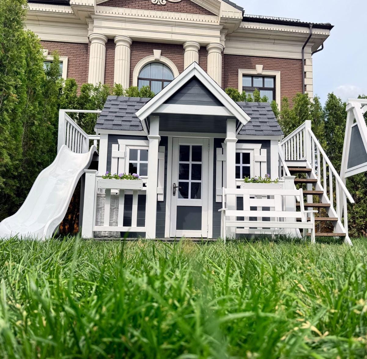 Two-Story Wooden Kids playhouse with attic with terrace and slide for outdoor use. Children's playhouse, playroom, colorful playhouse