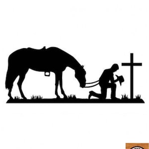 Pode incluir: Silhueta preta de um cavalo ajoelhado ao lado de um homem ajoelhado em oração diante de uma cruz. O homem está usando um chapéu de cowboy e o cavalo tem uma sela.