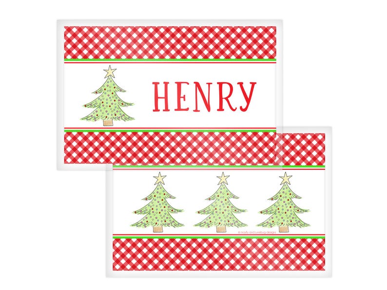 May include: Christmas-themed placemats with a red and white checkered border and a green and white stripe. One placemat features the name "HENRY" in red, while the other has three Christmas trees. The trees are green with yellow star toppers.
