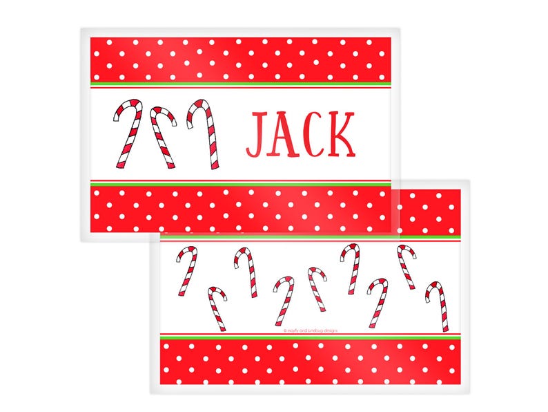 May include: Two rectangular Christmas-themed placemats. The top placemat has a red polka dot border, white center with two candy canes, and the name "JACK". The bottom placemat has multiple candy canes.