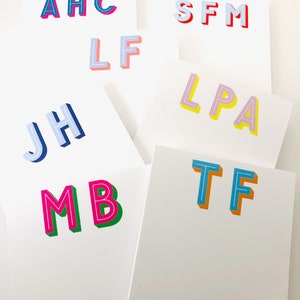 May include: A set of eight cards with colorful, 3D letter initials. The letters are in various colors, including blue, pink, yellow, green, and red. Each card has a single set of initials.