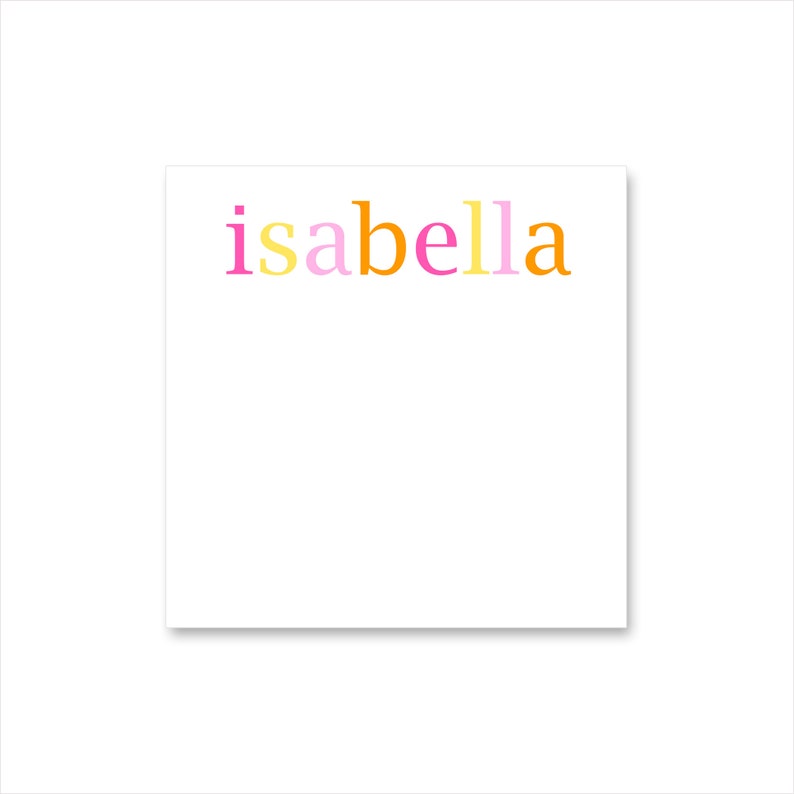 May include: A white square notepad featuring the name "isabella" in colourful lettering. The letters are pink, yellow, orange, and a lighter pink. The notepad is set against a white backdrop.