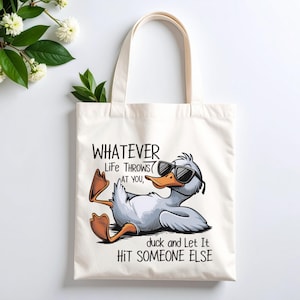 May include: Cream-colored tote bag featuring a cartoon duck wearing sunglasses, reclining with its feet up. The text reads "Whatever life throws at you, duck and let it hit someone else."