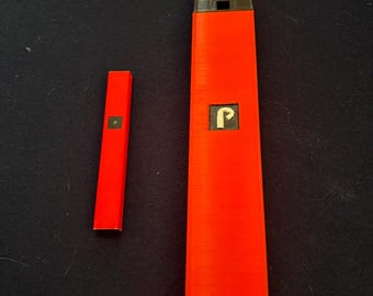 Könnte beinhalten: Zwei rote und schwarze elektronische Verdampfer, einer ist größer als der andere. Der größere hat eine schwarze Oberseite und einen weißen Buchstaben "P" auf der Vorderseite.